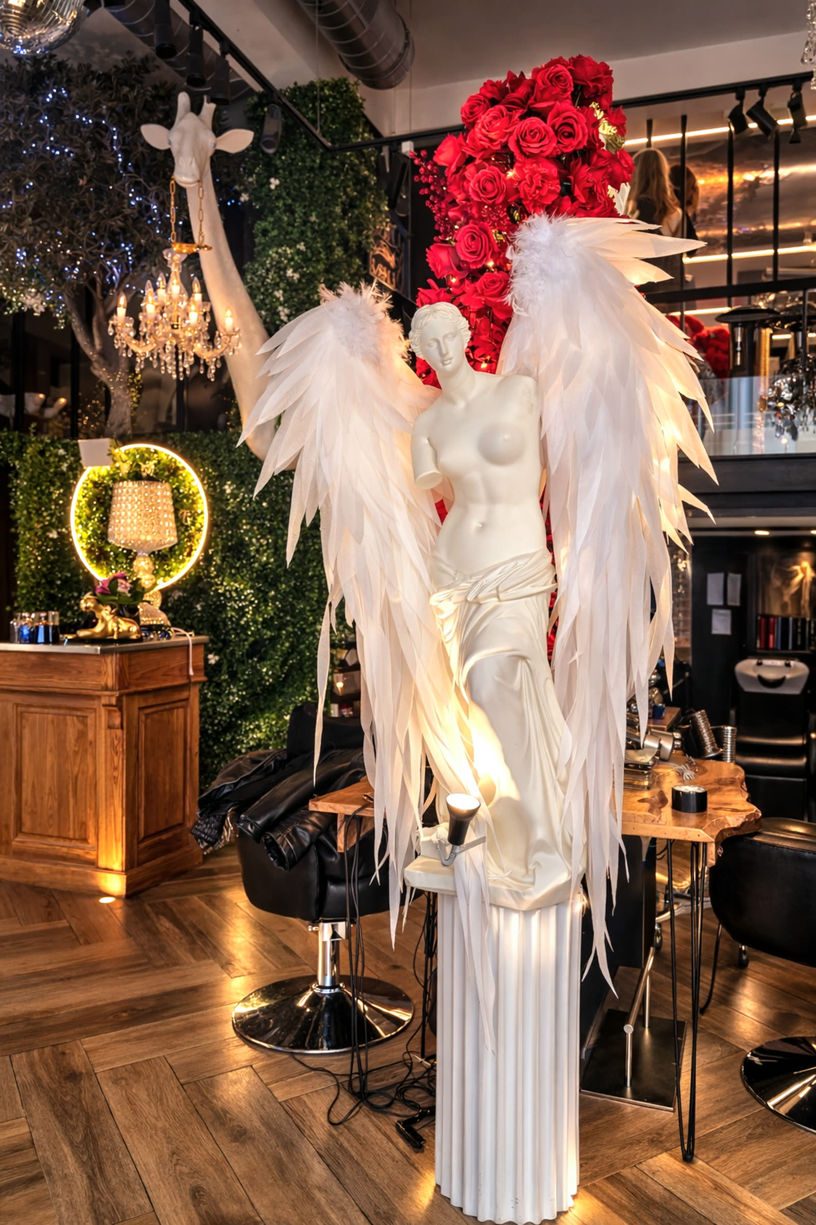 Détail de décoration du salon Unik — mur de roses rouges et statue ailée